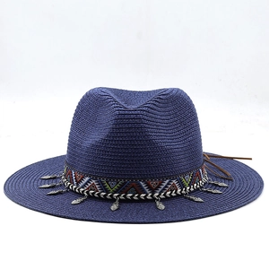 Détail du chapeau de paille bleu foncé avec ruban ethnique et breloques feuilles