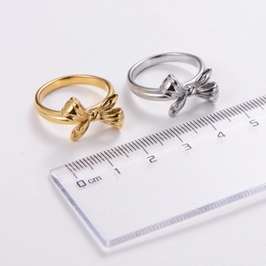 Gold and silver bow hollow rings with 1.8cm diameter shown on a ruler scale