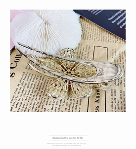 Detailed view of elegant gold hollow flower hair claw clip with intricate metalwork