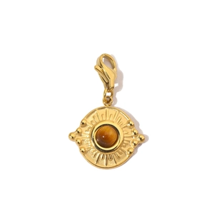Detailed shot of a gold-plated sun-eye pendant with a brown stone and lobster clasp