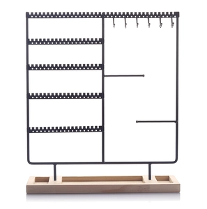 Detail of wooden base jewelry organizer with black metal hooks for earrings and necklaces