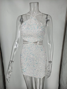 Détail du haut court dos nu à paillettes blanches et de la mini-jupe sur un mannequin