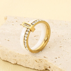 Detail of gold titanium steel ring with white ceramic inlay and cubic zirconia stones
