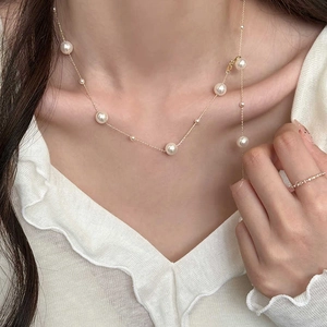 French vintage pearl necklace featuring gold chain and mixed size pearls on model