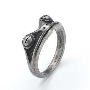 Macro view of vintage silver frog ring showing intricate oxidized metal textures and details