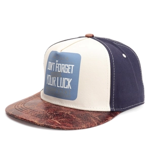 Close-up of tricolor snapback hat with blue embroidery and brown leather brim detail