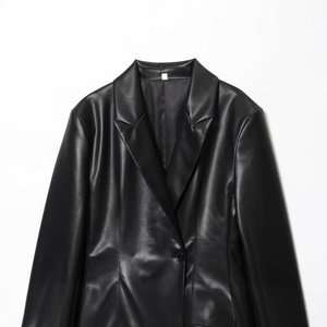 Front view of a slim fit black faux leather blazer with lapels and button closure