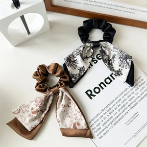 Detailed view of satin hair scrunchies with long streamers in vintage landscape prints