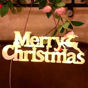 Dettaglio della luce LED Merry Christmas bianco caldo con sagoma di renna e fiori
