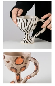 Detail of handmade ceramic goblets with zebra and leopard prints and curved handles