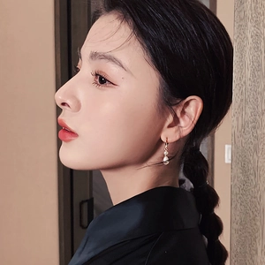 Close-up of elegant French style baroque pearl hoop earrings worn by a model
