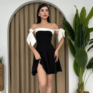 Elegant off-shoulder A-line dress with black body and white bow-accented sleeves