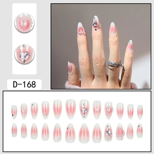 Unghie finte a mandorla sfumate rosa con cuori di perle, strass e dettagli glitter