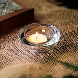 Elegante glazen kaarshouder met theelichtje op rustiek jute voor huisdecoratie