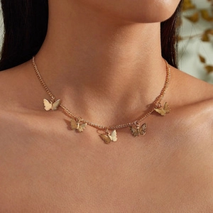 Close-up of elegant gold butterfly choker necklace worn gracefully by a model