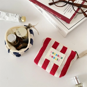 Flat lay of small striped canvas pouches for cosmetics and lipstick organization