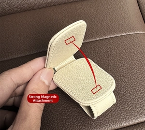 Macro detail of beige leather sun visor clip showing strong magnetic adsorption design