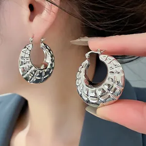Chunky silver horseshoe earrings with textured braided pattern and metallic finish