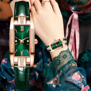 Macro detail of rectangle green quartz watch with gold diamond case and leather strap