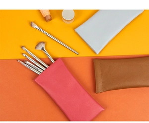 Flat lay of colorful leather storage pouches for brushes and optical glasses cases