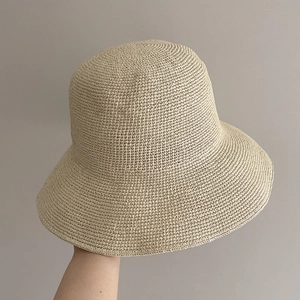 Detailed view of the fine hand-woven texture on this beige straw bucket sun hat