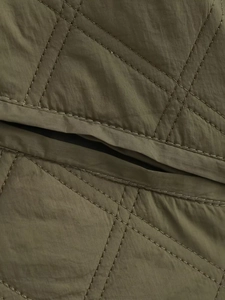 Nahaufnahme der Rautensteppung und des Nylonmaterials der armeegments dieser grünen Jacke