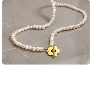 Detail of French baroque freshwater pearl necklace with golden flower OT clasp on wood