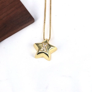 Detailed close-up of a gold star pendant necklace featuring a sparkling zircon letter X