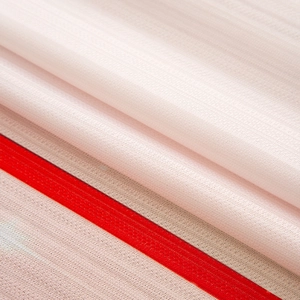 Macro shot of breathable white Christmas fabric with sharp red stripes and mesh texture