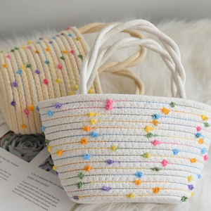 Handwoven cotton rope tote bag with colorful dots and twisted handles for stylish storage