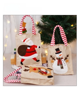 Three Christmas burlap gift bags featuring Santa Claus, Snowman, and Reindeer designs
