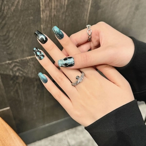 Dark aesthetic press-on nails with blue-green glitter and crescent moon art on long coffin shape