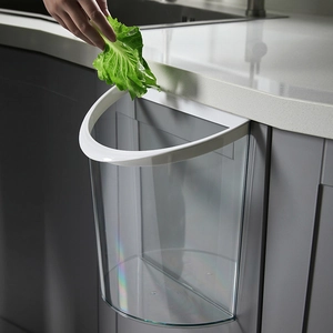 Wall-mounted transparent kitchen trash can for food waste shown on a modern cabinet door
