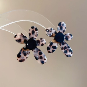 Macro shot of vintage flower earrings with leopard print acetate and black center