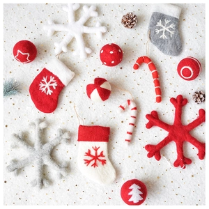 Close-up of handmade wool felt Christmas ornaments with snowflakes and stockings