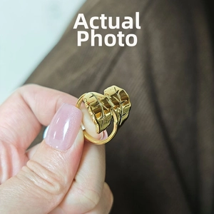 Detail view of 18k gold leaf-shaped ring with fine vein textures and adjustable open band