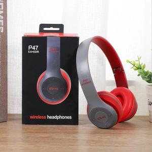 Detailed view of gray and red P47 wireless headphones on wooden desk with retail box