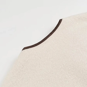 Vue macro du tissu polaire sherpa crème avec bordure contrastée en tissu marron foncé