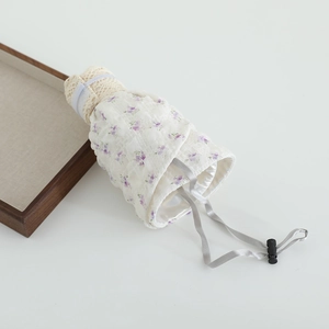 Gros plan d'un sac à cordon floral avec bordure en dentelle et doublure argent