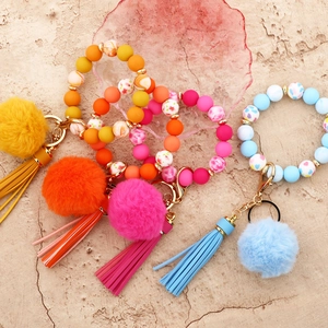 Colorful silicone bead wristlet keychains with matching tassels and pom poms in four colors