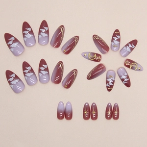 Faux ongles amande avec dégradé violet, motifs nuages et breloques lune étoile dorées