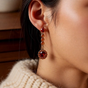 Gros plan de boucles d'oreilles vintage avec pierres précieuses rouges sur mannequin