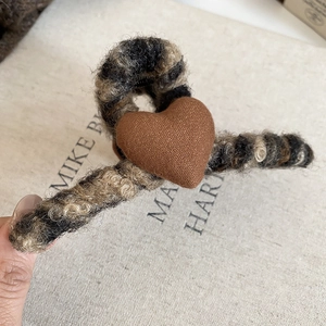 Détail de la pince à cheveux léopard avec flocage et un décor de cœur en peluche marron