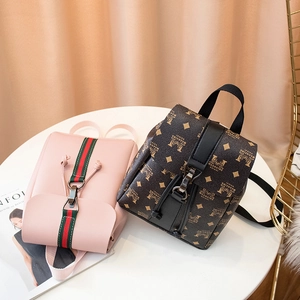 Stylish mini backpacks with printed patterns and safety lock on a white table