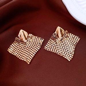 Close-up of geometric mesh earrings with rose gold plating on deep velvet background