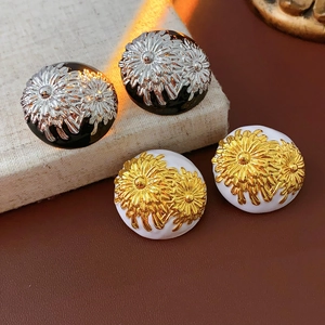 Detail of vintage flower stud earrings in gold and silver finish with daisy relief
