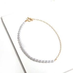 Detail of half pearl and gold chain necklace with decorative OT toggle clasp