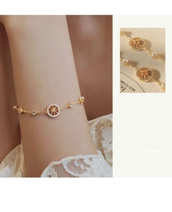Detailed view of a gold compass bracelet with sparkling cubic zirconia on a wrist
