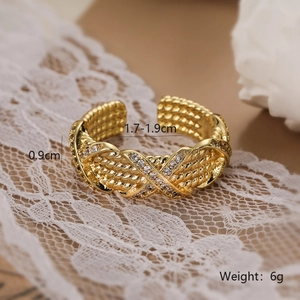 Detail view of gold woven open ring with white zircon measuring 0.9cm in width