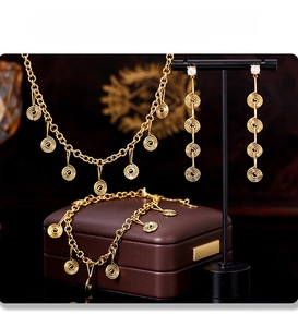 Detailed view of gold PVD plated spiral jewelry set with necklace and stone earrings